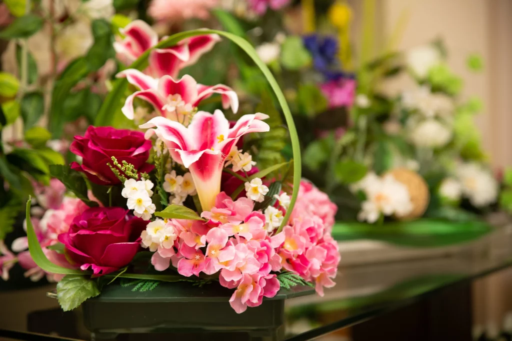 Arrangement floral coloré composé de lys et de roses pour obsèques.