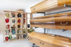 Exposition de cercueils en bois et d'urnes cinéraires dans une agence funéraire.