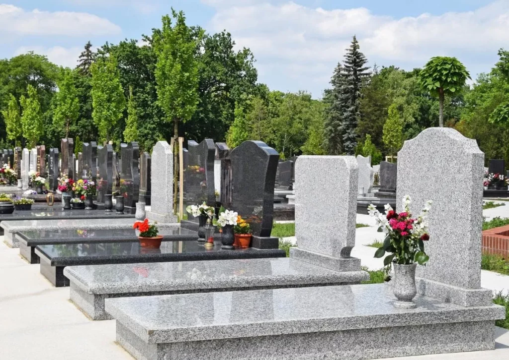 Alignement de stèles mortuaires bordées de massifs de fleurs parfaitement entretenus